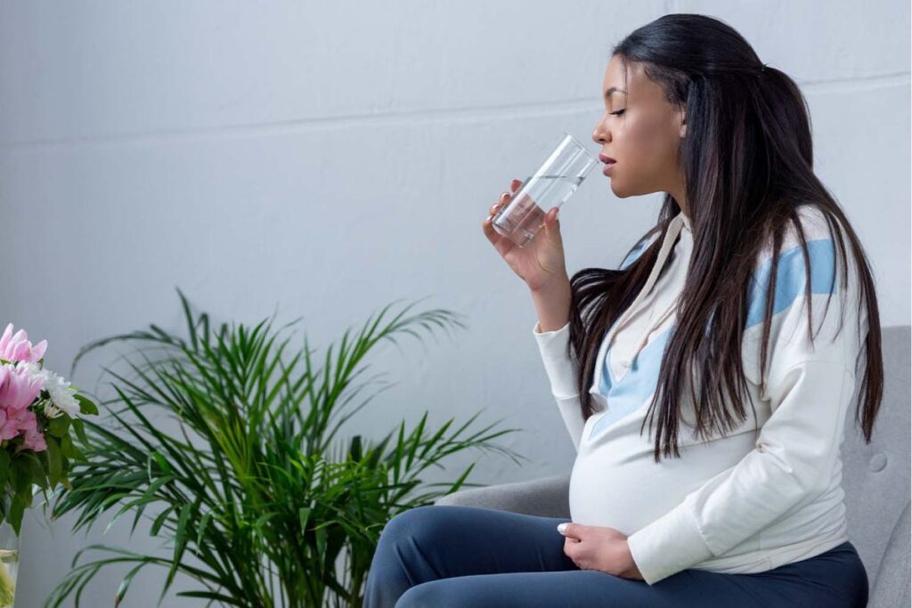 A pregnant lady drinking water during pregnancy